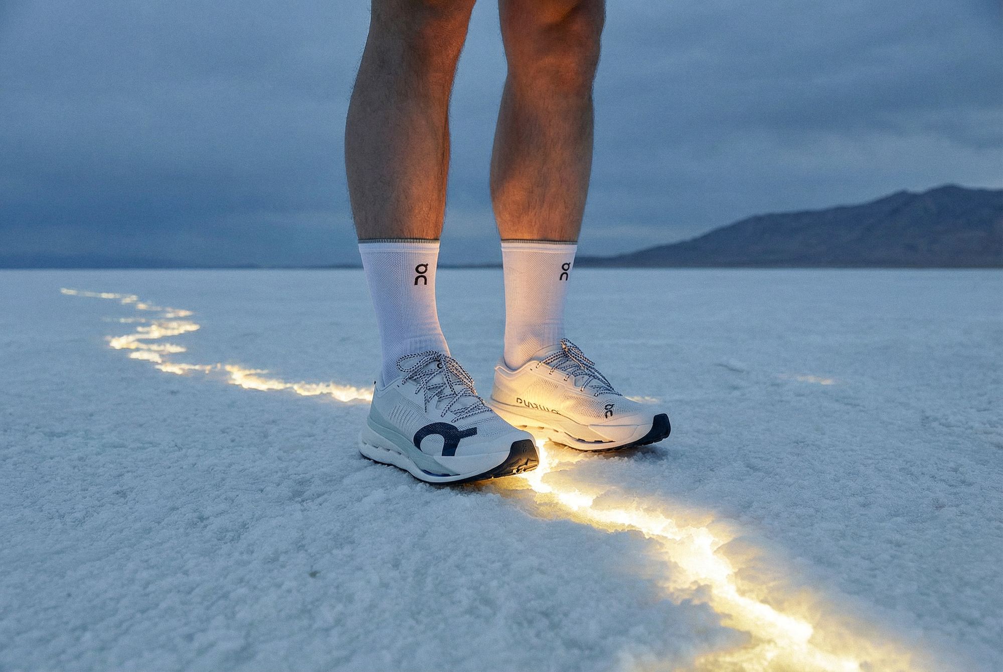 Production IA pour ON Running : chaussures de course sur sol salé, traînée lumineuse traversant le cadre